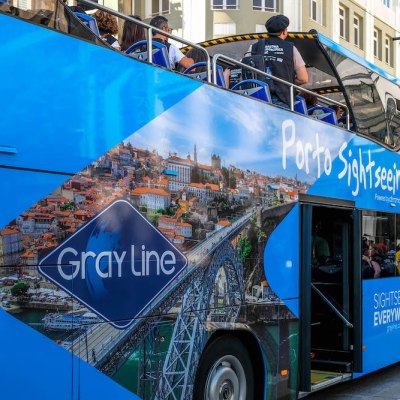 a blue double decker bus parked on the side of a building