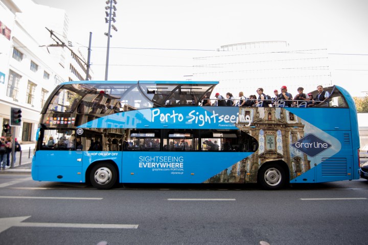 a blue double decker bus parked on the side of a road