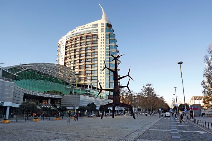 a group of people walking down a street next to tall buildings