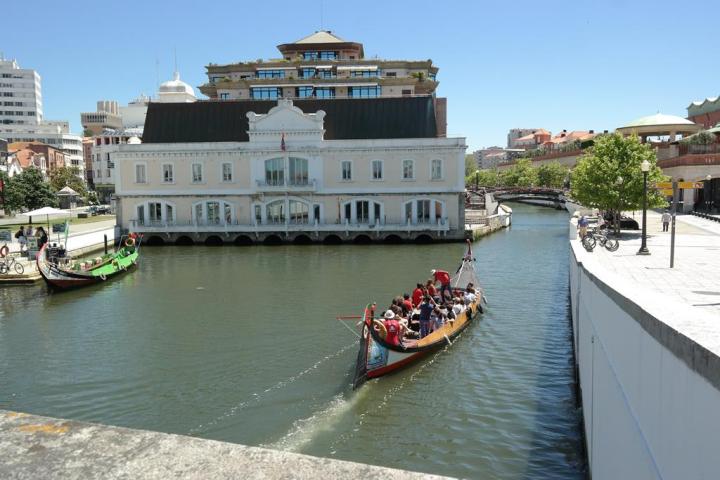 a boat floating along a river next to a body of water
