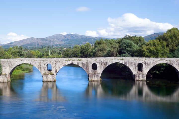 a train crossing a bridge over a body of water