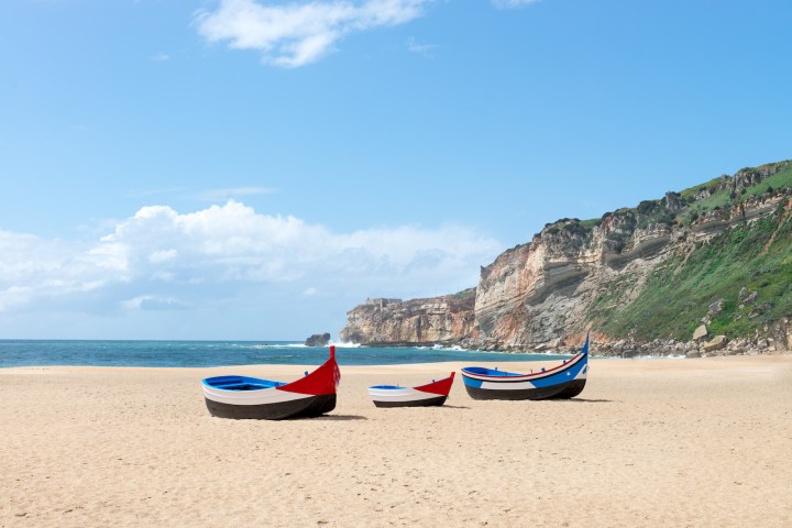 a boat sitting on top of a sandy beach
