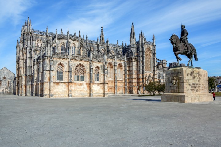 a statue in front of Batalha Monastery