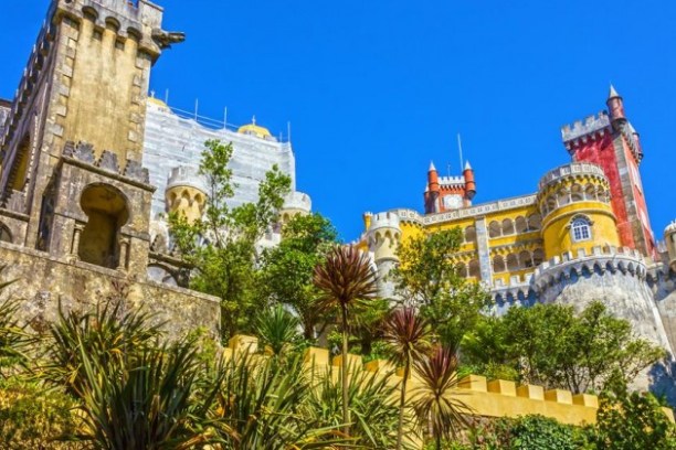 a castle with a clock tower in front of a building