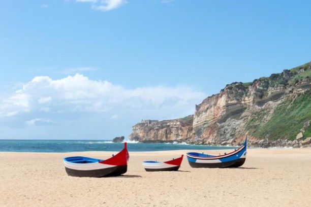 a boat sitting on top of a sandy beach