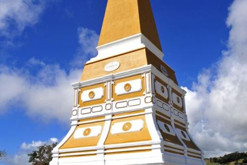 a large clock tower sitting in the grass