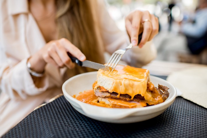 a woman sitting at a table with food and a spoon