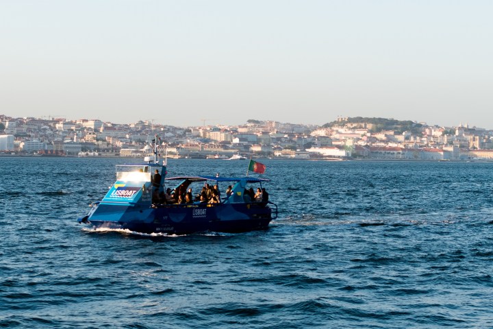 a small boat in a body of water with a city in the background
