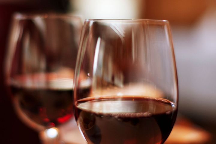 Two glasses of red wine on a table with a blurred background.