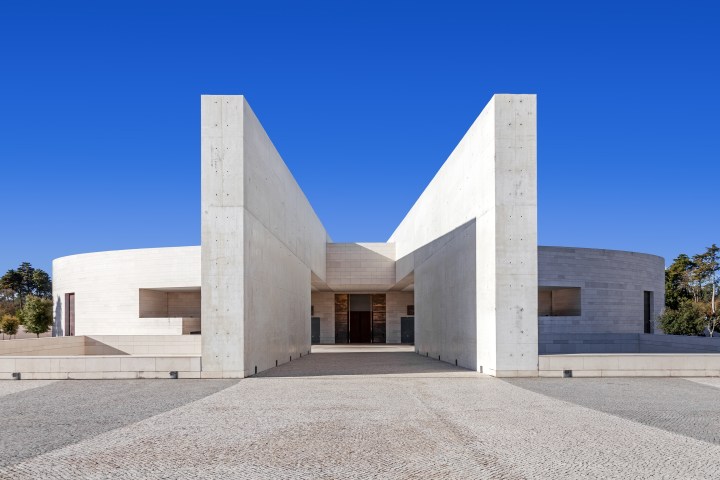 Modern concrete building with angular design against blue sky.