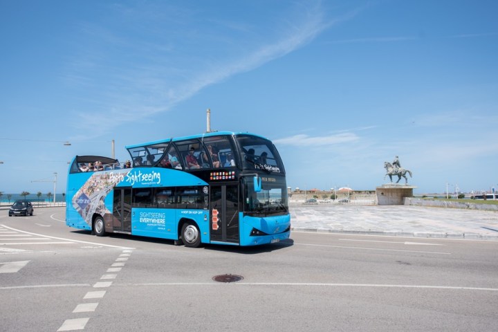 a blue bus parked on the side of a road