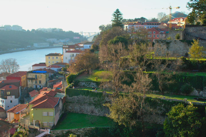 River view with hillside houses and trees, under a clear sky.