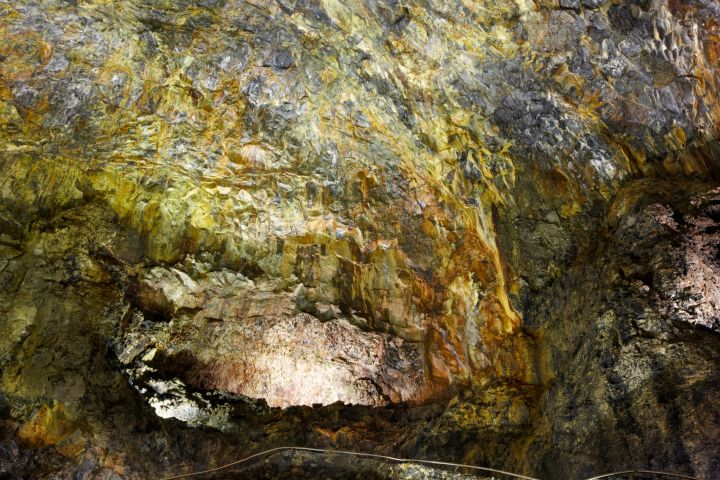 Colorful rock formation on a cave wall with textured mineral deposits.